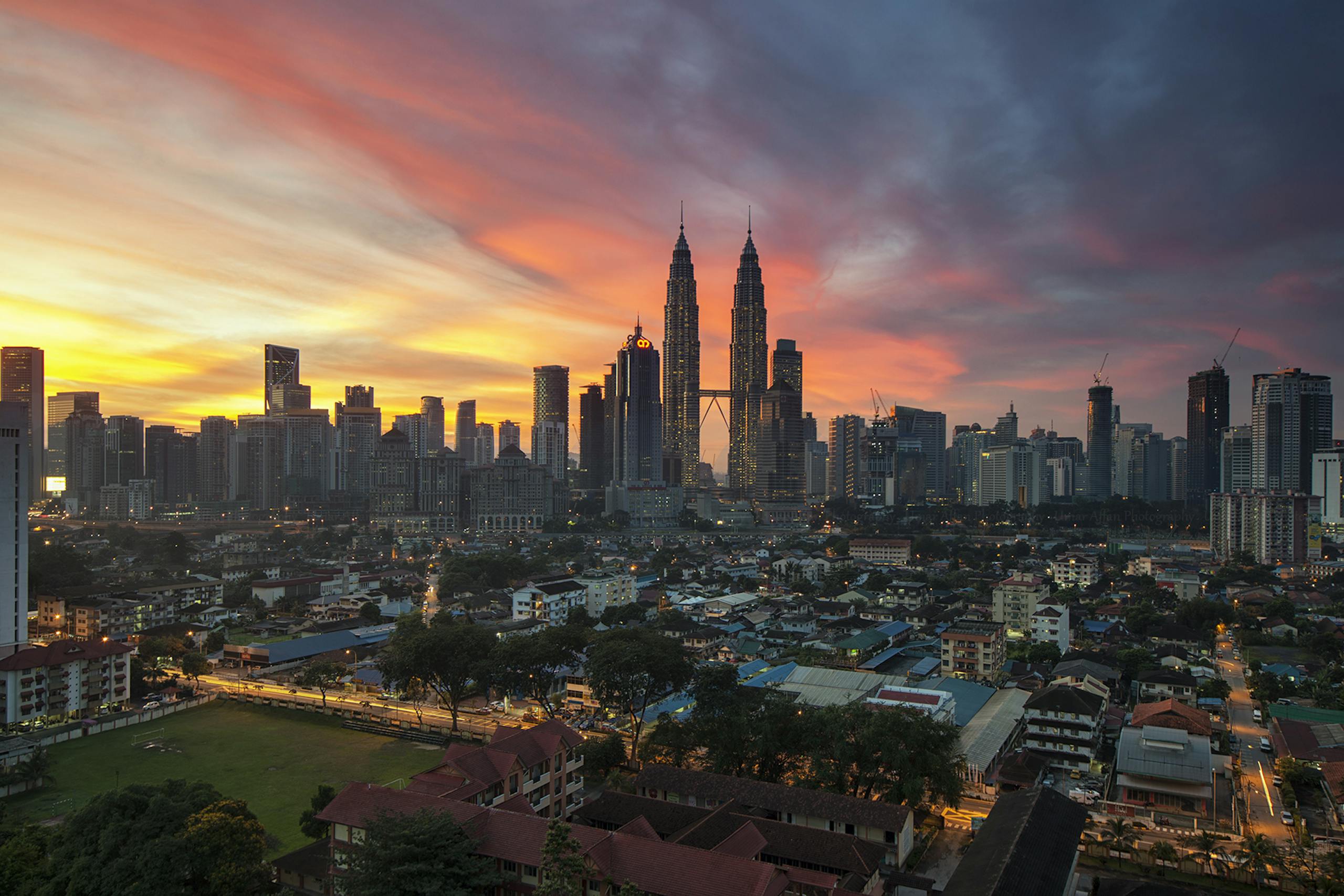 Breathtaking view of Kuala Lumpur skyline with Petronas Towers at sunset, showcasing vibrant urban architecture.